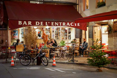 a group of people sitting at tables outside of a restaurant