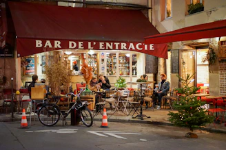 A cozy café terrace with locals chatting over coffee in the village center of Portet-sur-Garonne.