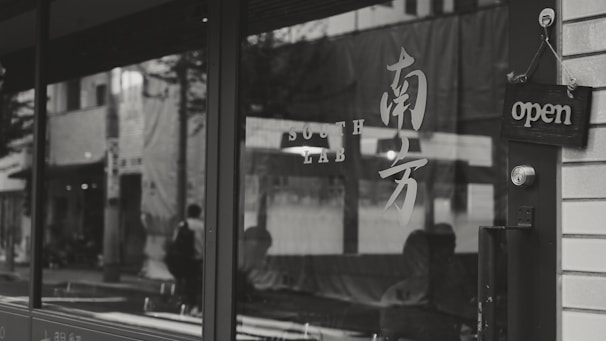 A locksmith assisting a business owner at a storefront entrance.