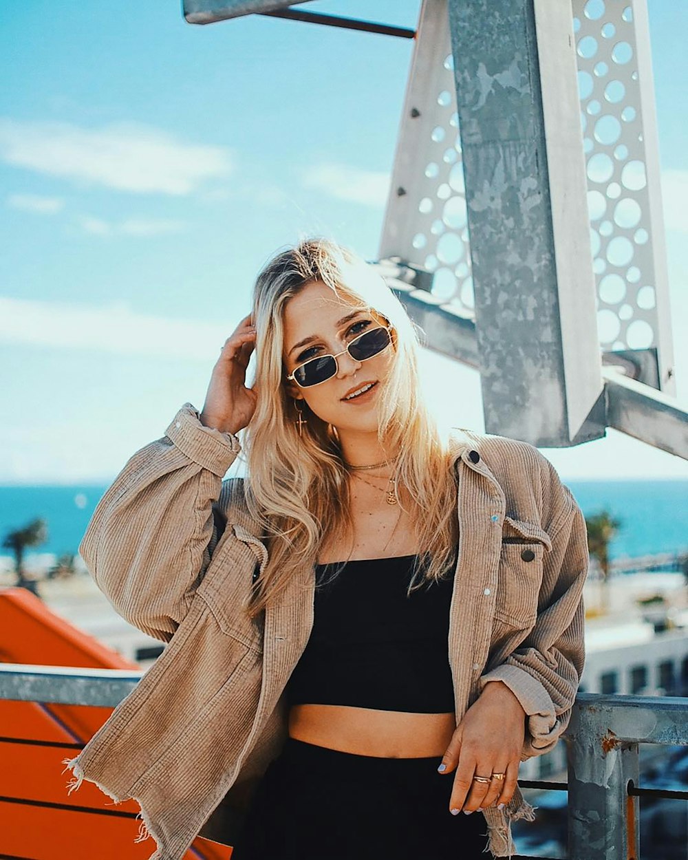 a woman in a crop top and jacket posing for a picture