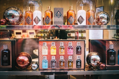 A display of Molton Brown products arranged on shelves. The setup includes various bottles, presumably of scented products, and decorative metallic spheres. The reflection on the spheres adds an interesting visual element.