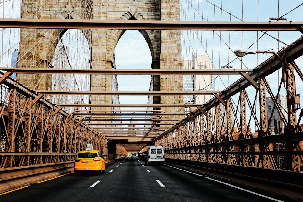 vehicles passing on Brooklyn Bridge during daytime