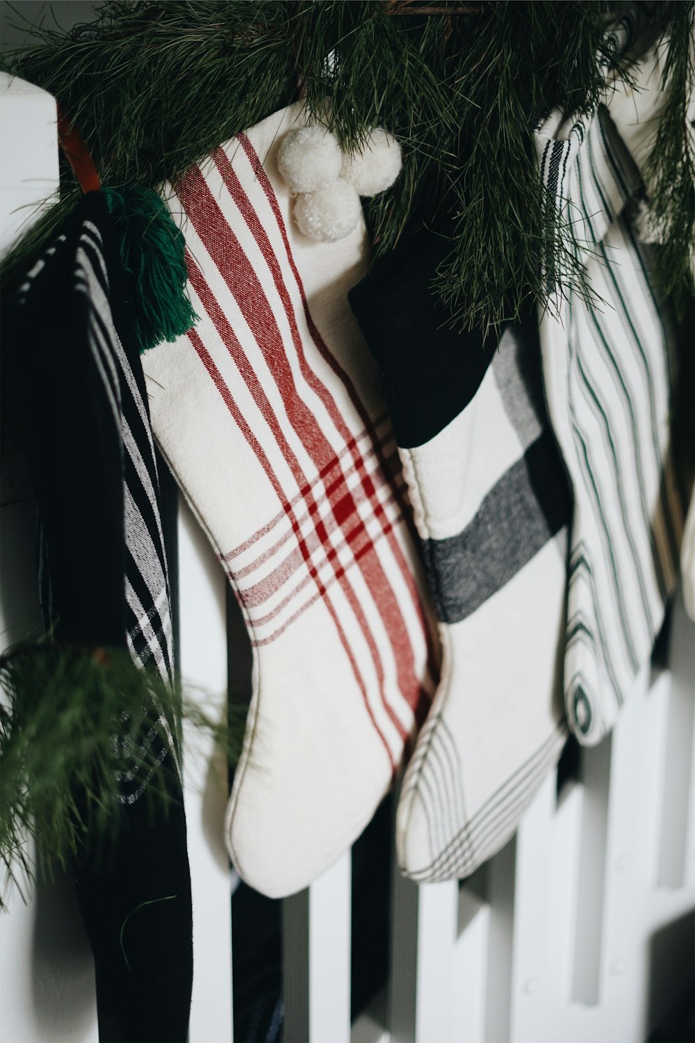 white and red Christmas stocking hanging near pine tree