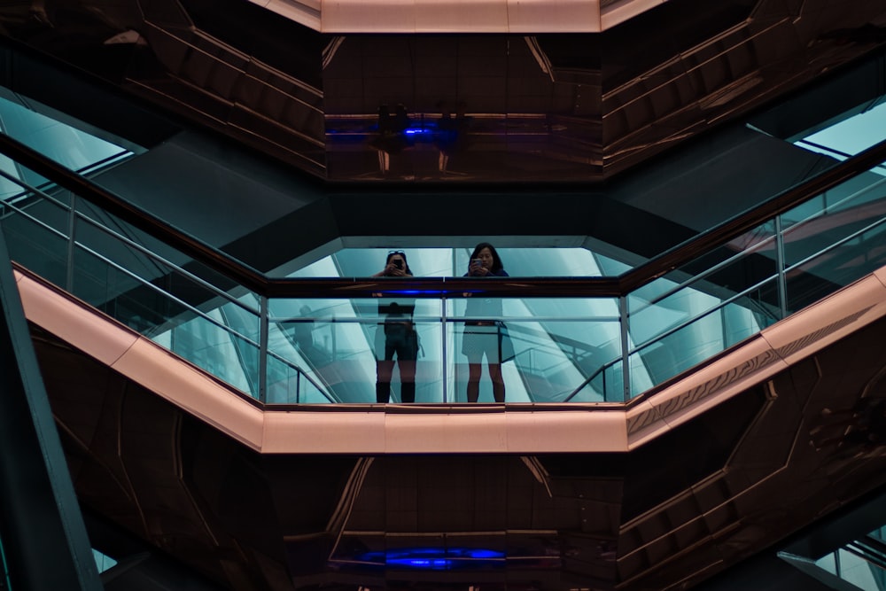 a couple of people standing on top of an escalator