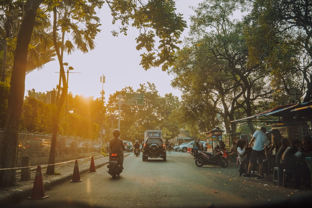 people on street and few vehicles on road during daytime