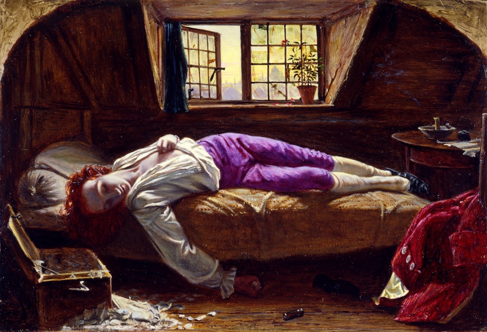 man lying on bed painting