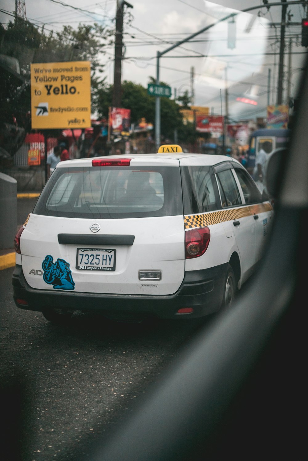 white Nissan vehicle on road