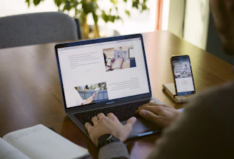person sitting near chain while using MacBook Pro