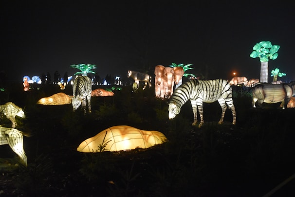 The Night Safari’s lush greenery illuminated by soft lighting, with a glimpse of nocturnal animals.