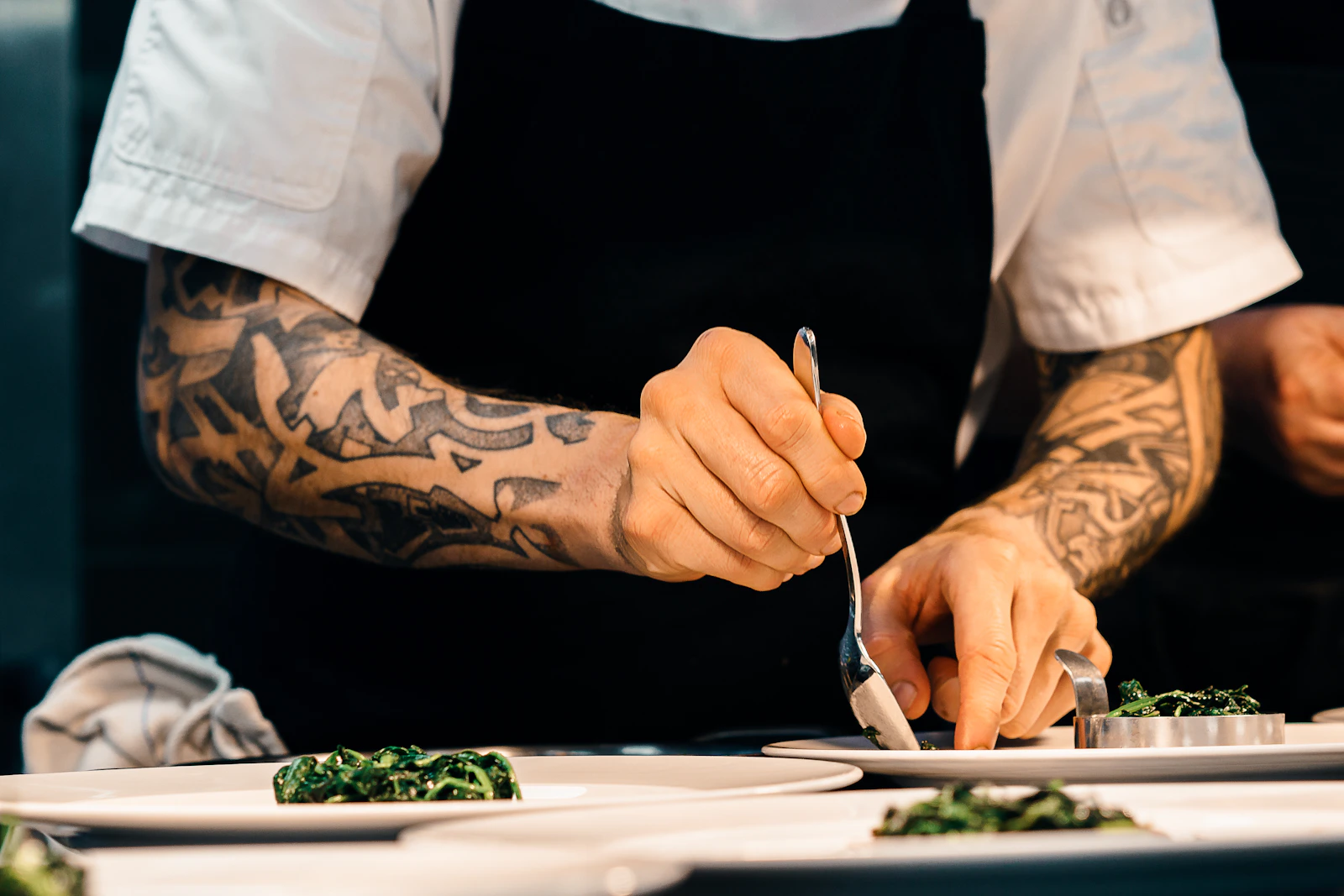 Chef working beneath commercial kitchen ventilation equipment