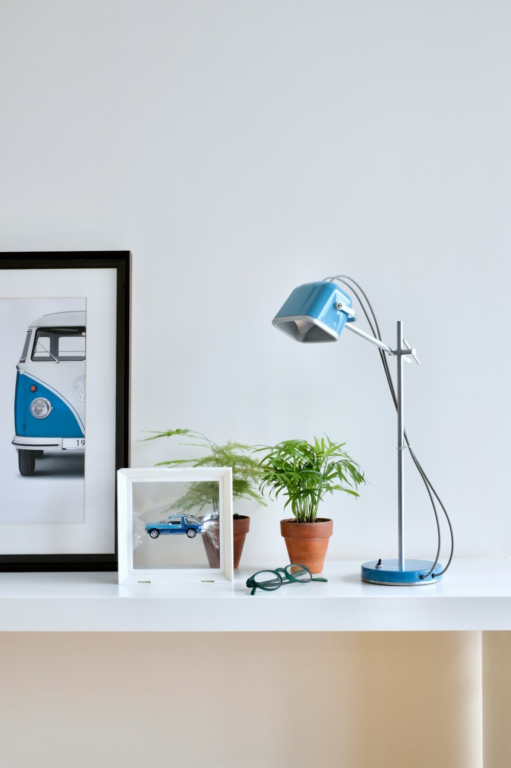 a picture of a vw bus on a shelf next to a lamp and a