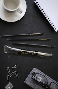 A cozy desk scene featuring Louisa LLC's stationery set with a ballpoint pen, notebook, and sticky notes arranged neatly.