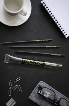 A beautifully arranged welcome kit with branded mugs, notebooks, and pens on a bright background.
