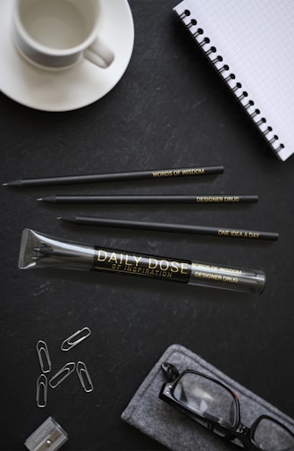 A stylish corporate gift set including engraved pens and notebooks on a sleek desk.