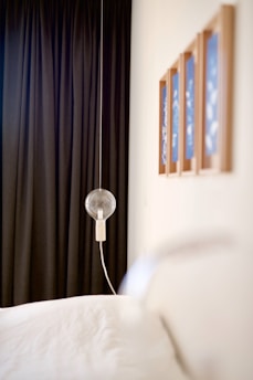 A minimalist bedroom featuring a delicate string of fairy lights draped above a calm, neutral-toned bed.