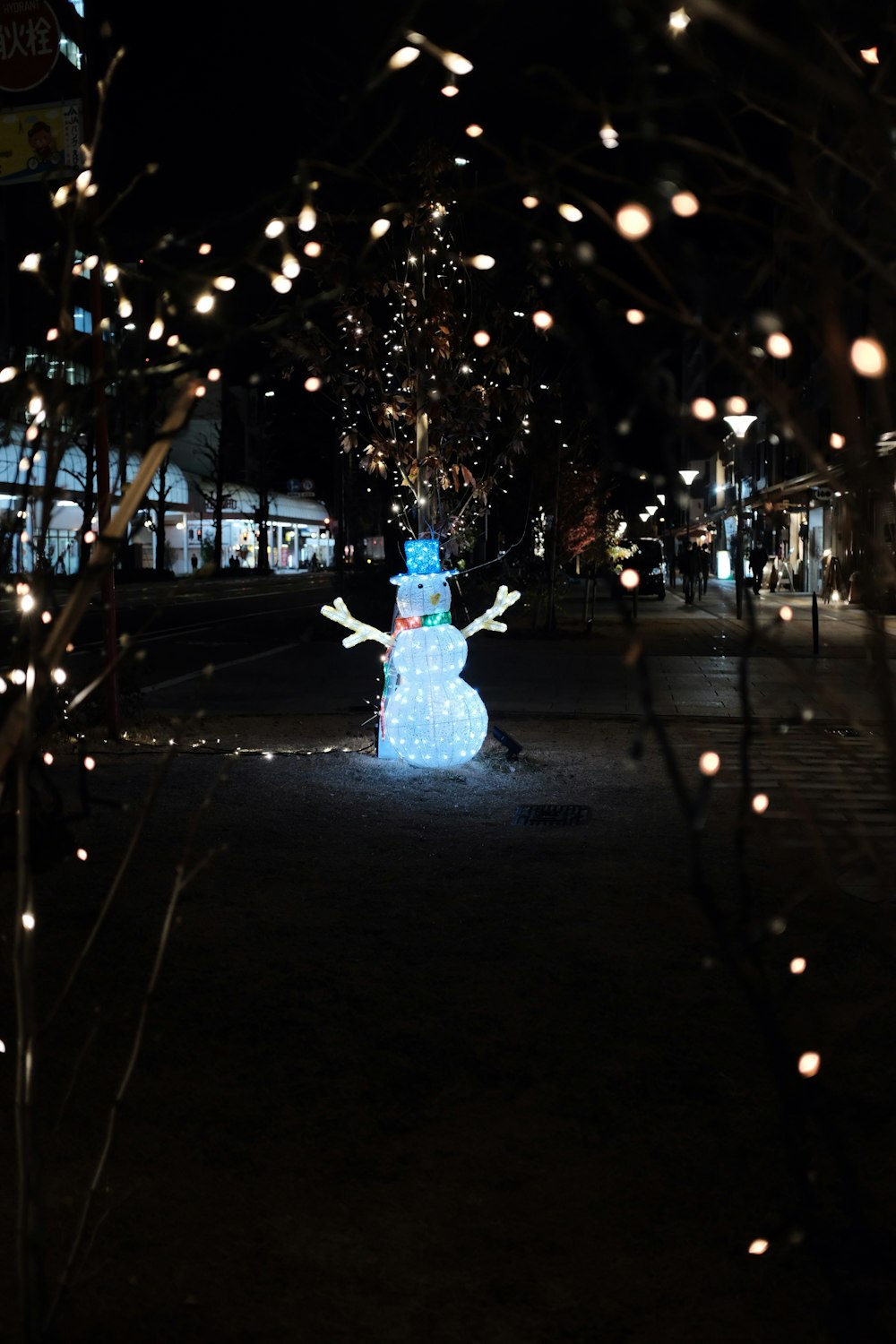 a lighted snowman in the middle of a street