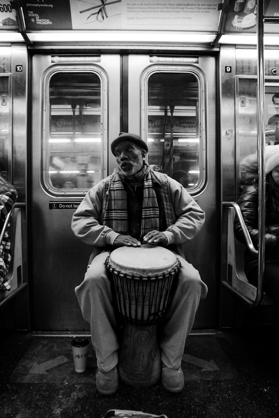 man playing djembe inside the train