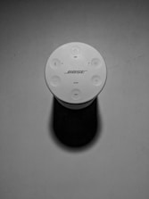Close-up image of a sleek Bose speaker with glowing controls.