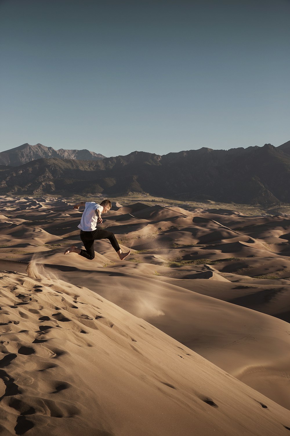 砂漠に飛び跳ねる男
