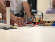 Close-up of hands assembling vibrant blocora blocks into a tower.