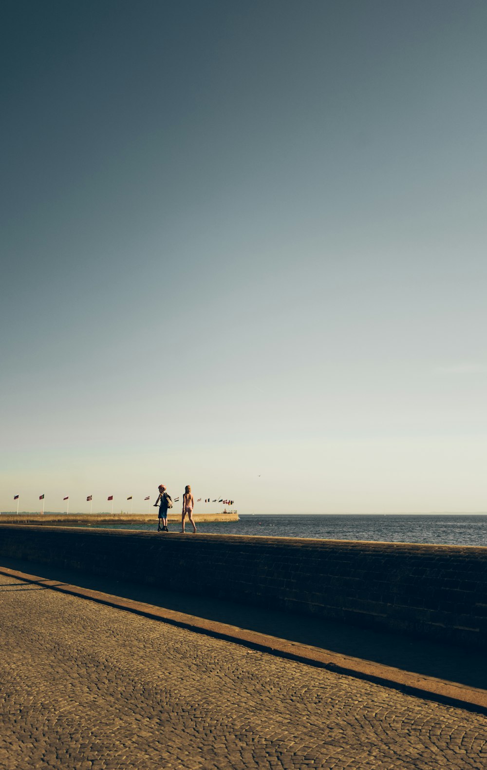 two people standing near body of water during daytime