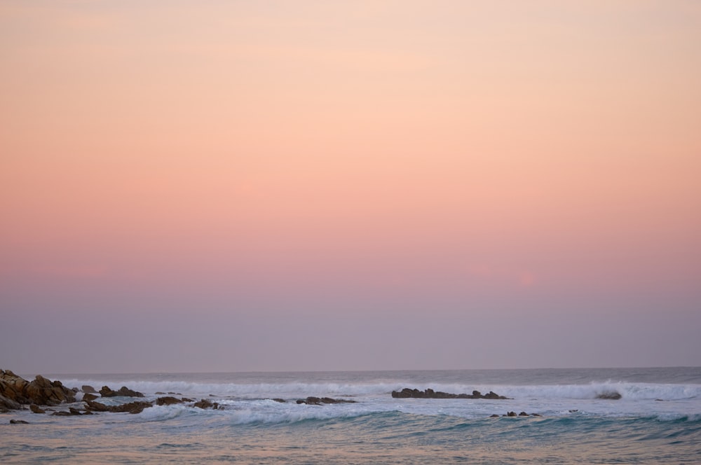 waves crashing on body of water