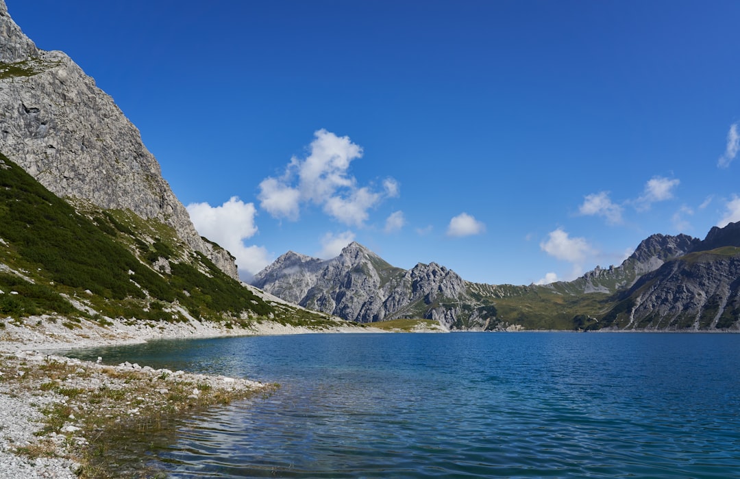 body of water near mountains during daytime