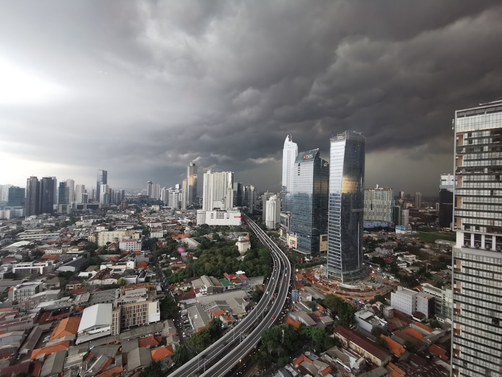 a cityscape with a train on the tracks in the foreground