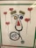 A creative artwork features elements resembling a face made from various objects, including a stethoscope forming the outline, yarn or string for the eyebrows, and colorful circular objects for the eyes. Surrounding the face are floating heart-shaped balloons with red color as the main theme.