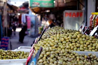 A vibrant market stall displaying colorful Spanish olives and peppers.