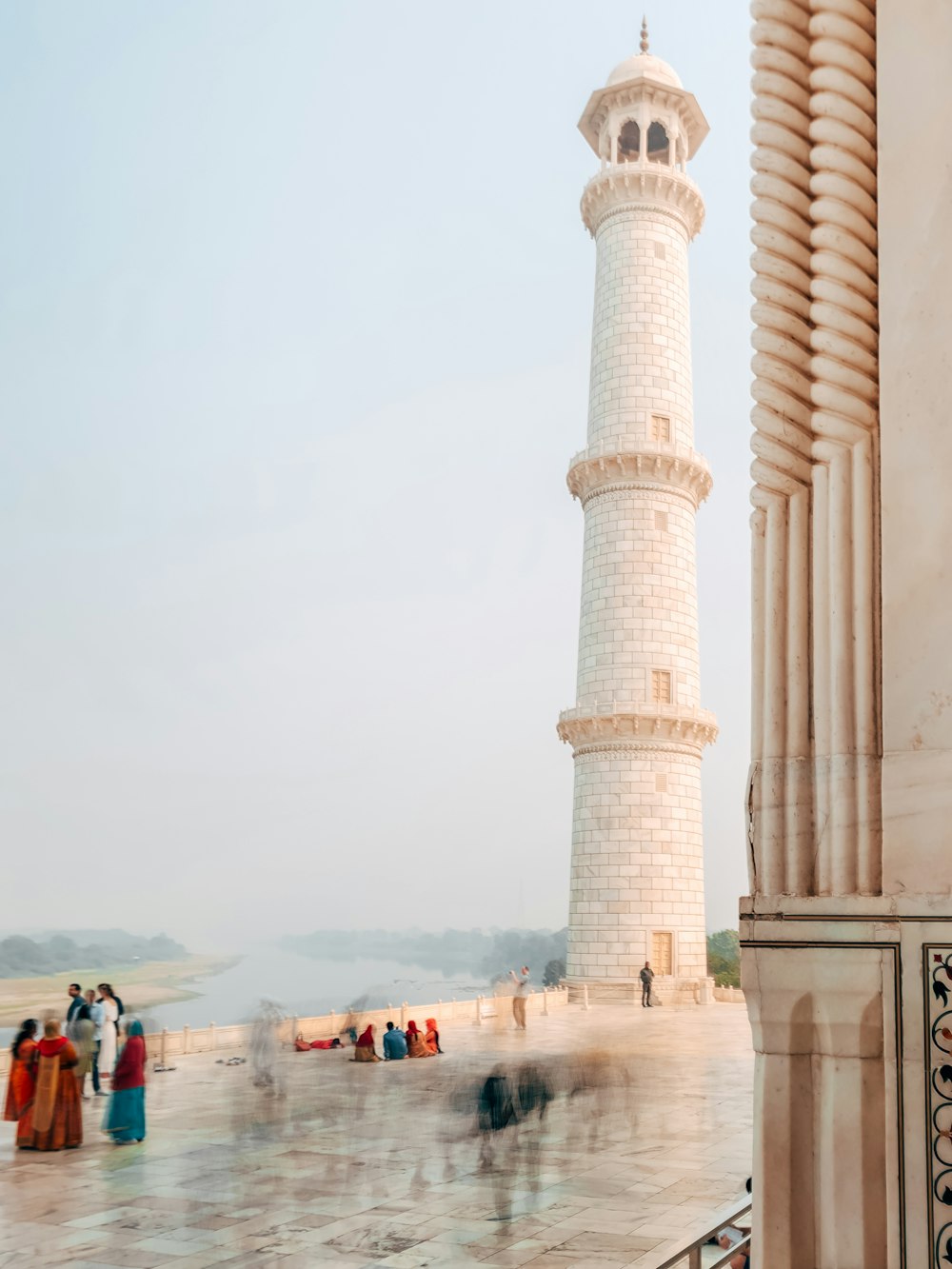 people walking near brown concrete tower painting