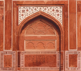 close-up photo of brown and white floral building door