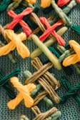 Delicate threads and vibrant yarns arranged on a textured fabric, evoking craft and heritage.