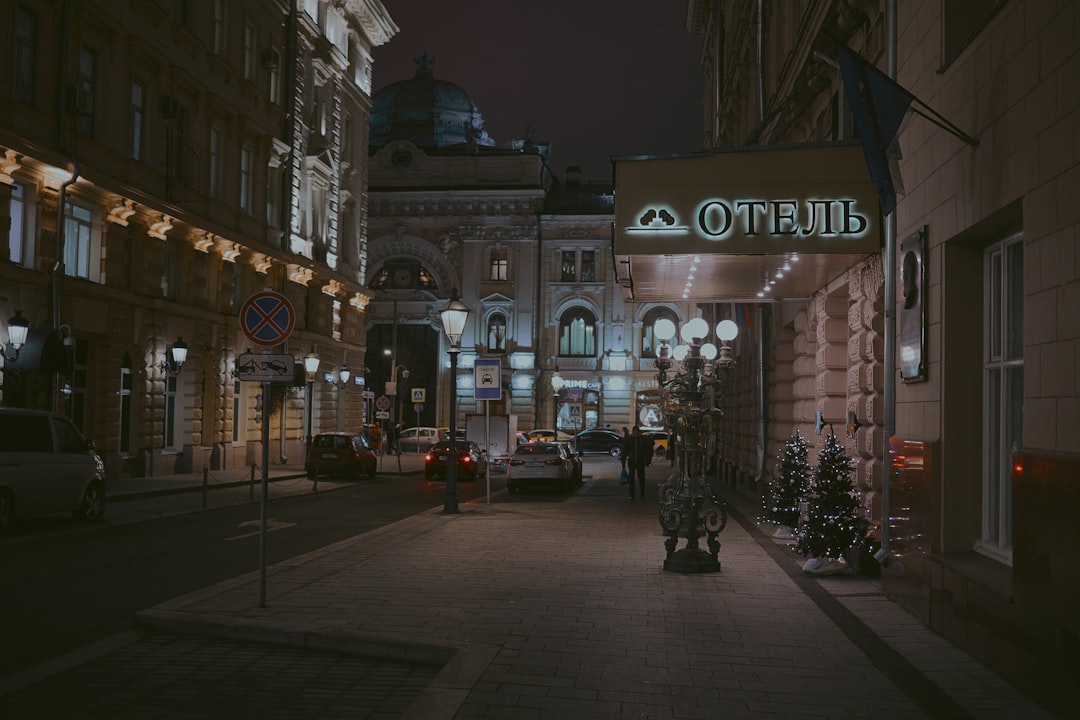 cars on road near sidewalk during night time