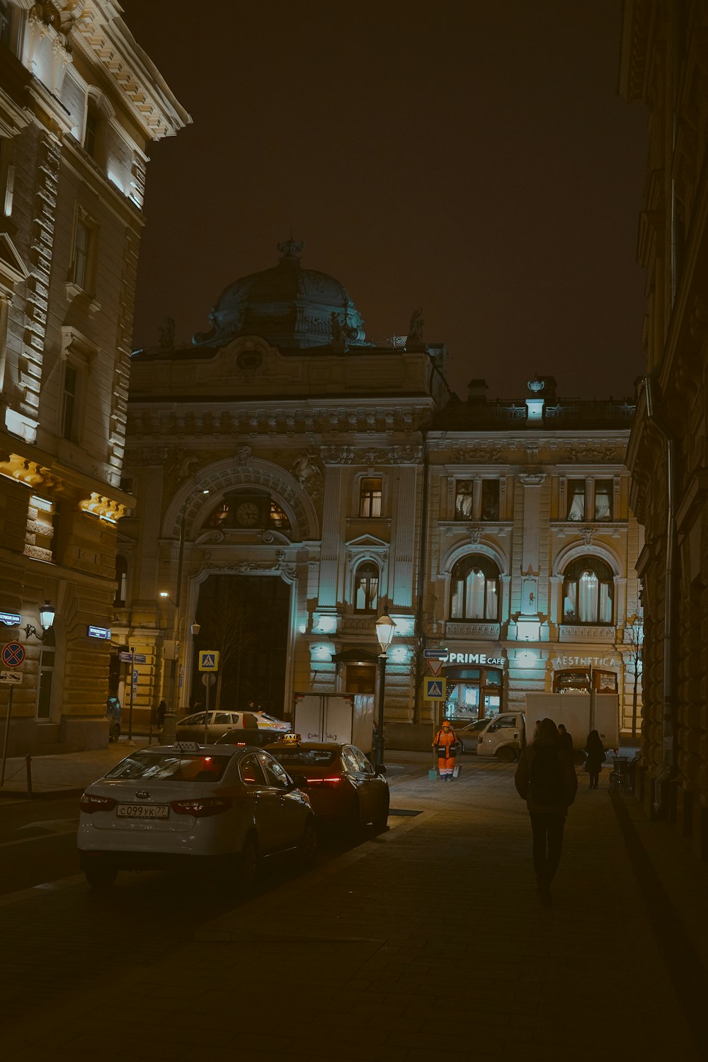 cars on road near high-rise building during night time