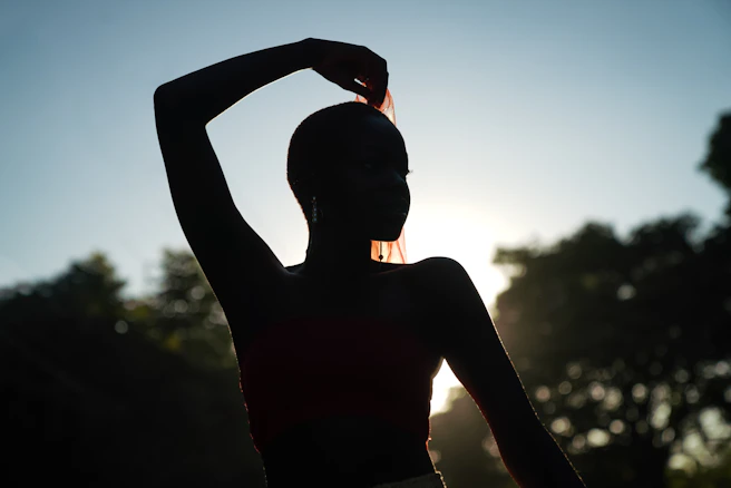 silhouette of woman during daytime. warrior pose