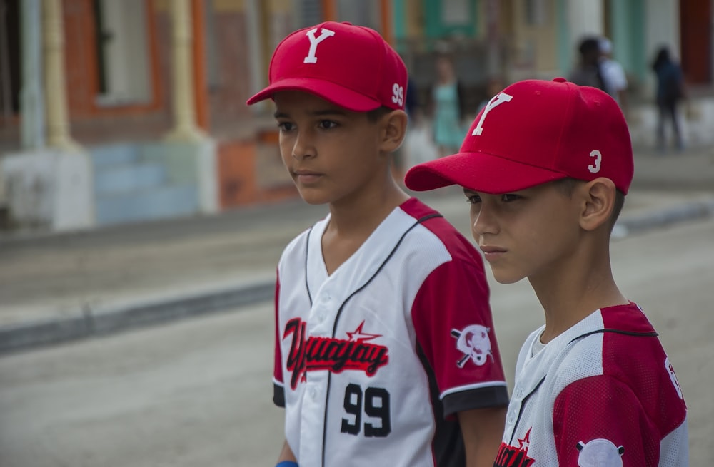 two boys wearing baseball uniform during day