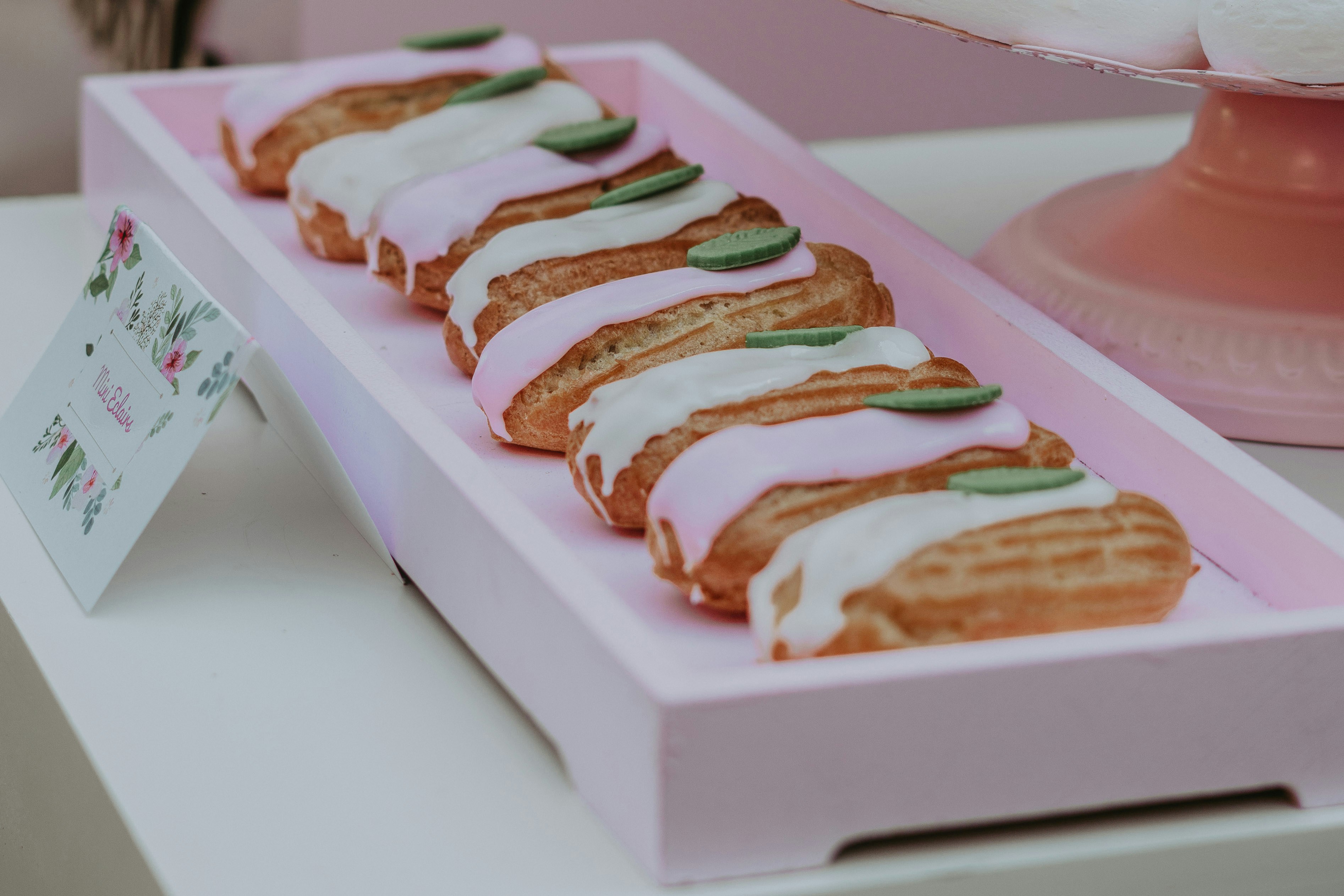 cream covered foods on pink tray
