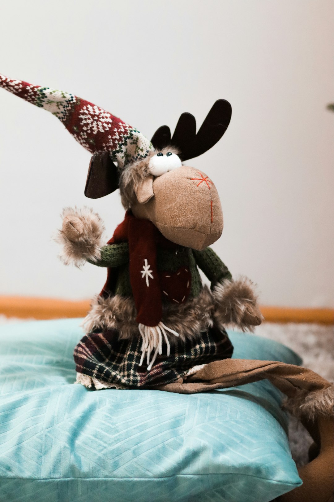 brown and red moose christmas plush toy on pillow