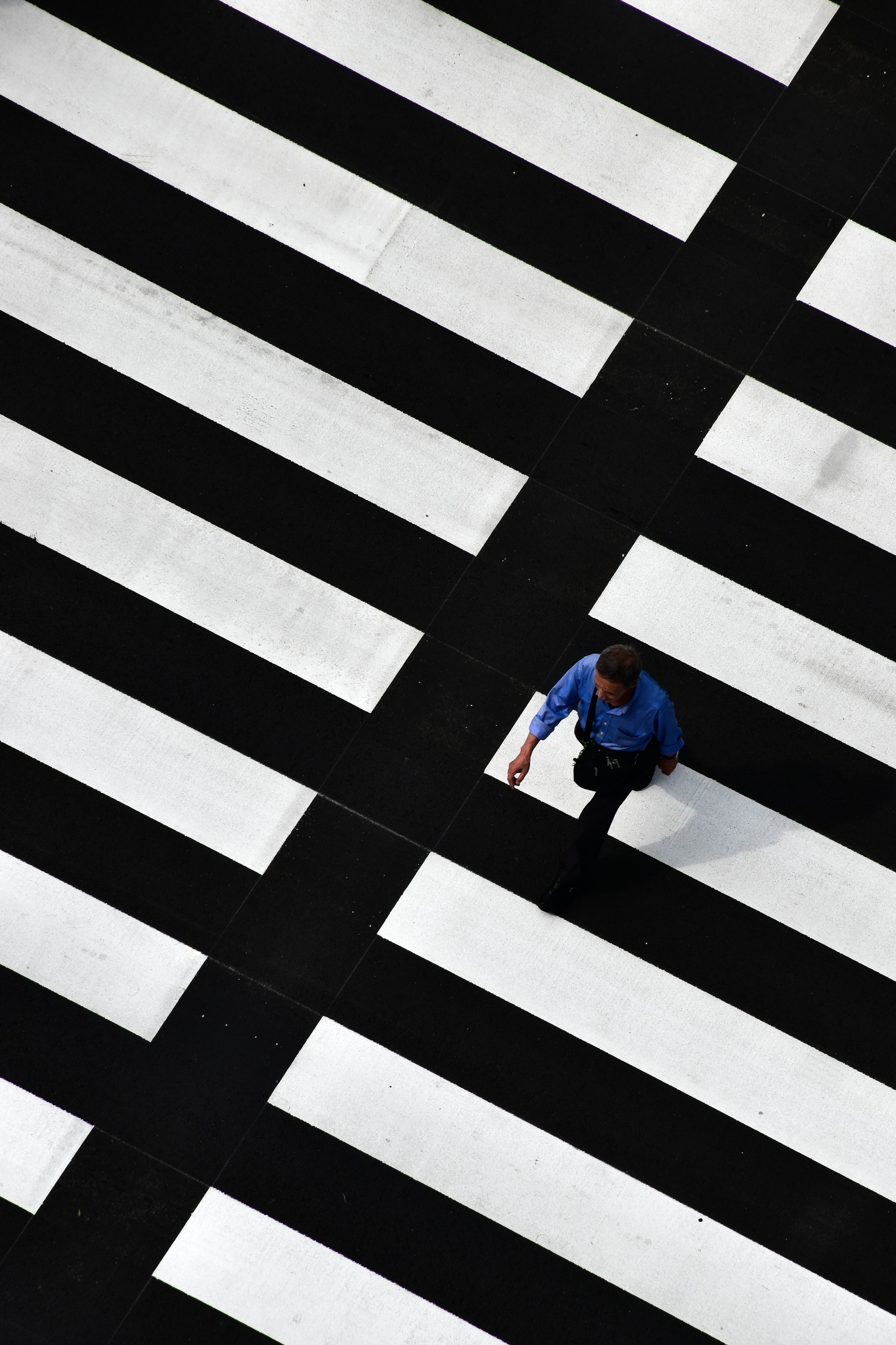 man walking on crosswalk during day