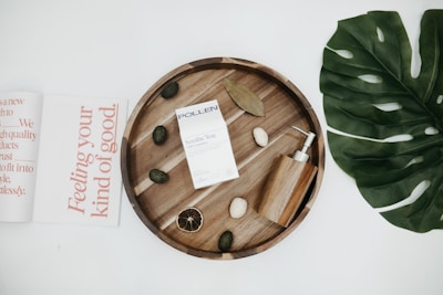 A serene flat lay of george60 herbal products surrounded by fresh green leaves and soft beige linens.