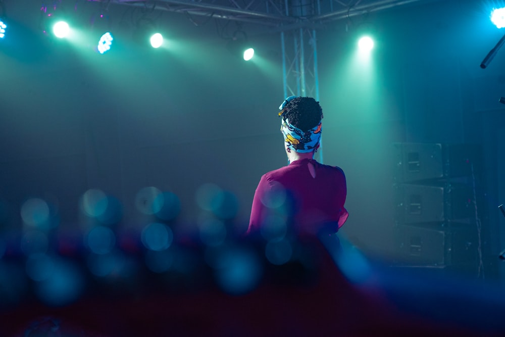 a woman in a red dress standing in front of a stage