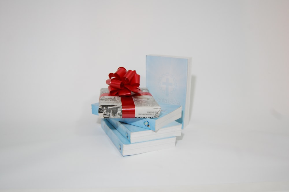 a stack of books with a red bow on top