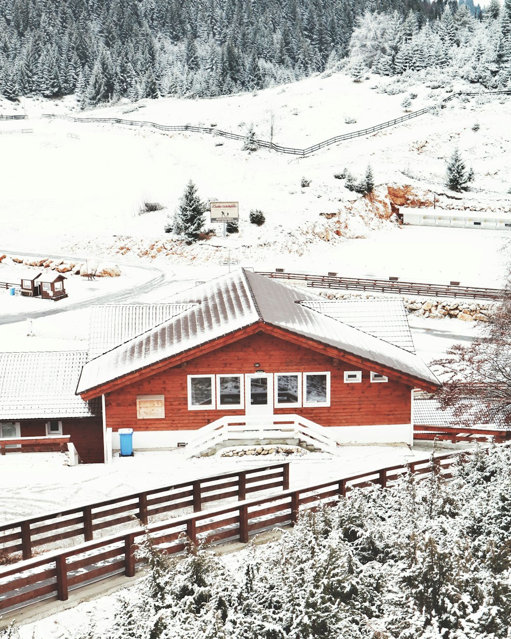 aerial view of snow covered house and pine trees