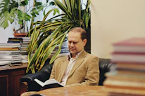 A person reading an ebook on a tablet in a comfortable chair.