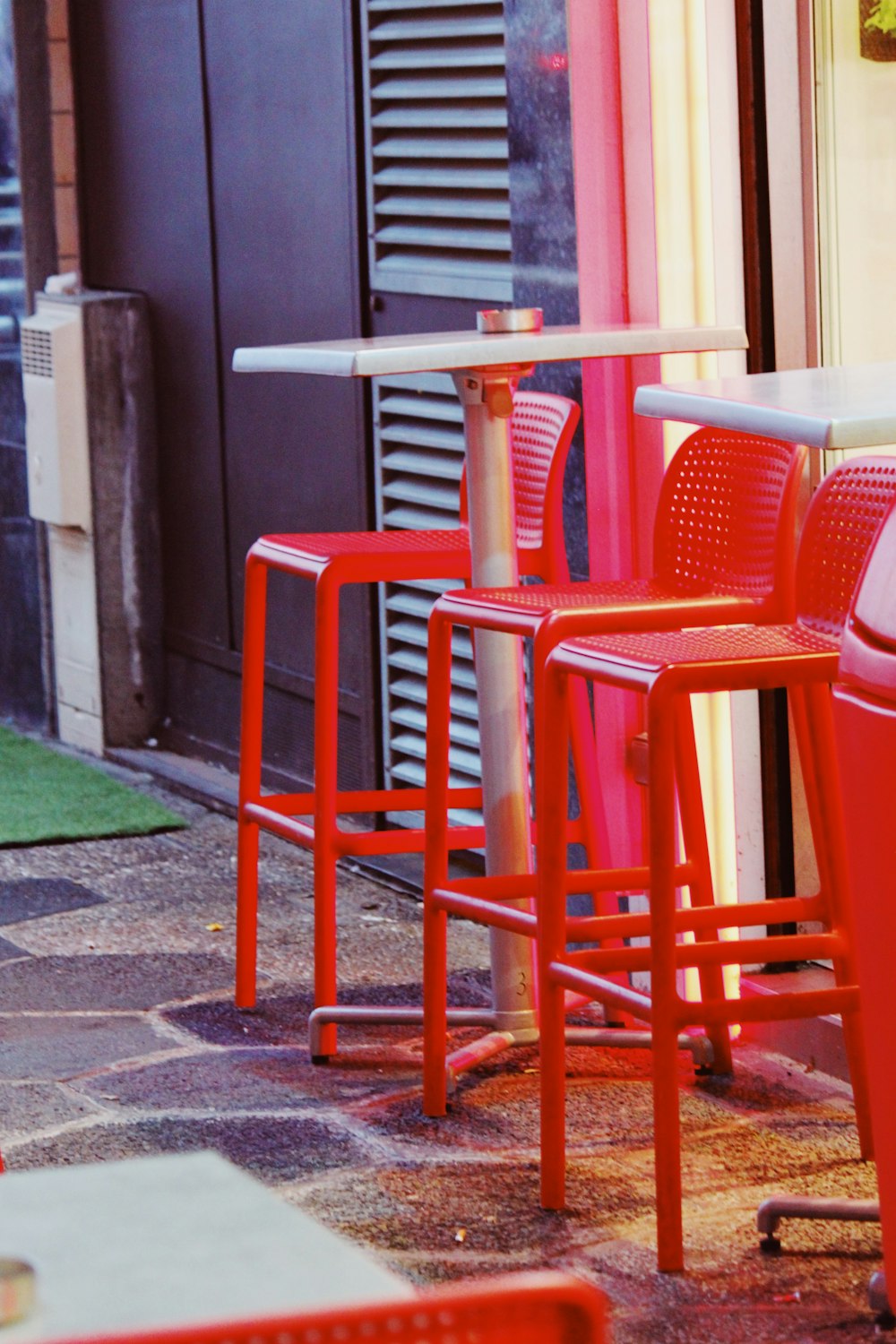 red plastic bar chairs near table