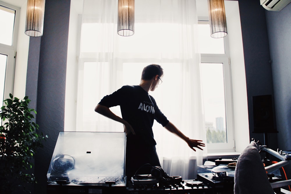 man standing inside room near window