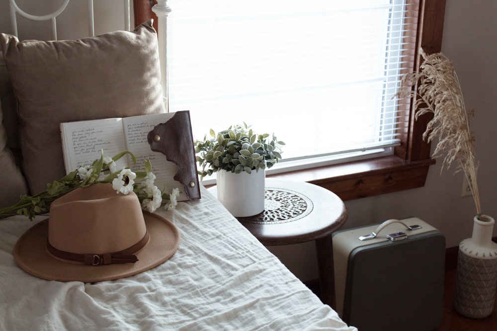 white-petaled flower on bed near nightstand and window