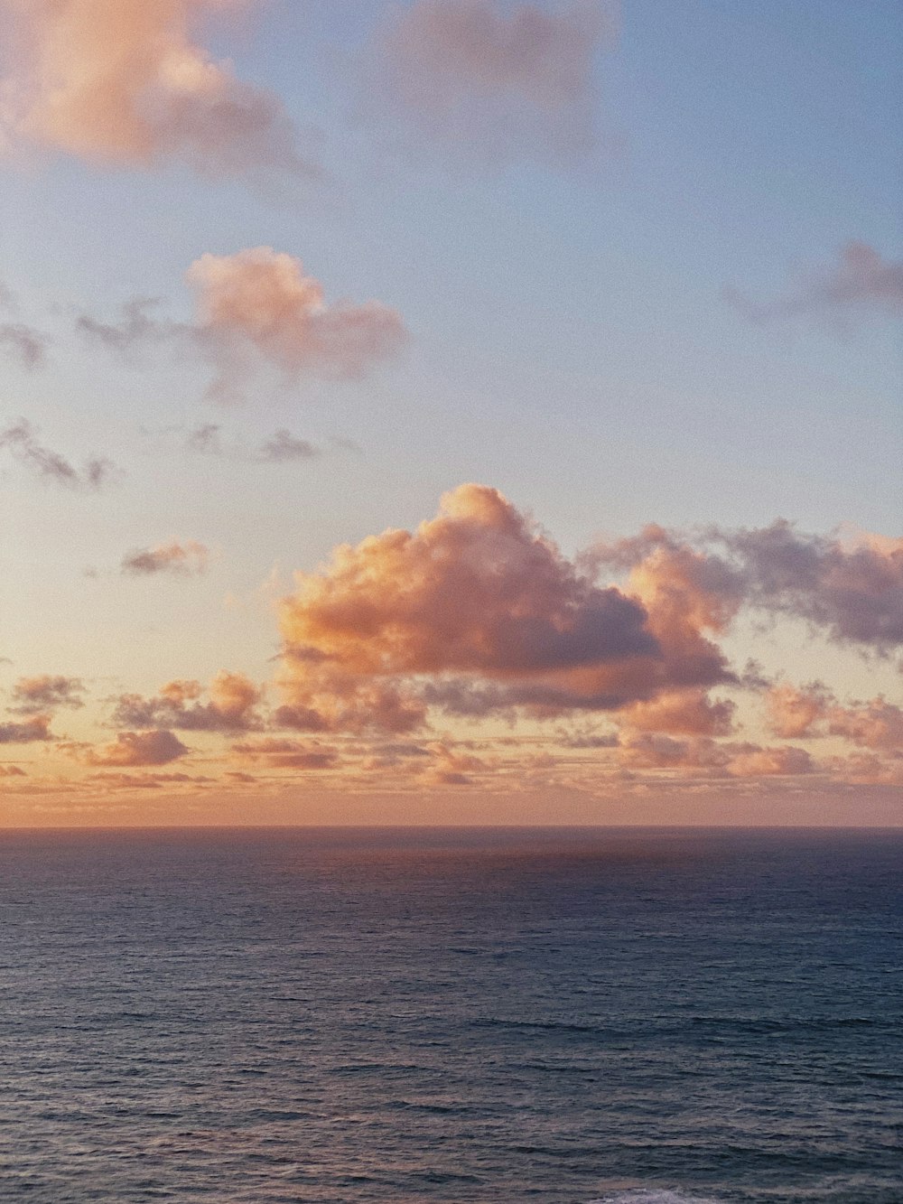 blue body of water under orange and blue sky