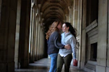 Adrianna and Lucas sharing a joyful laugh under a pastel-decorated archway.